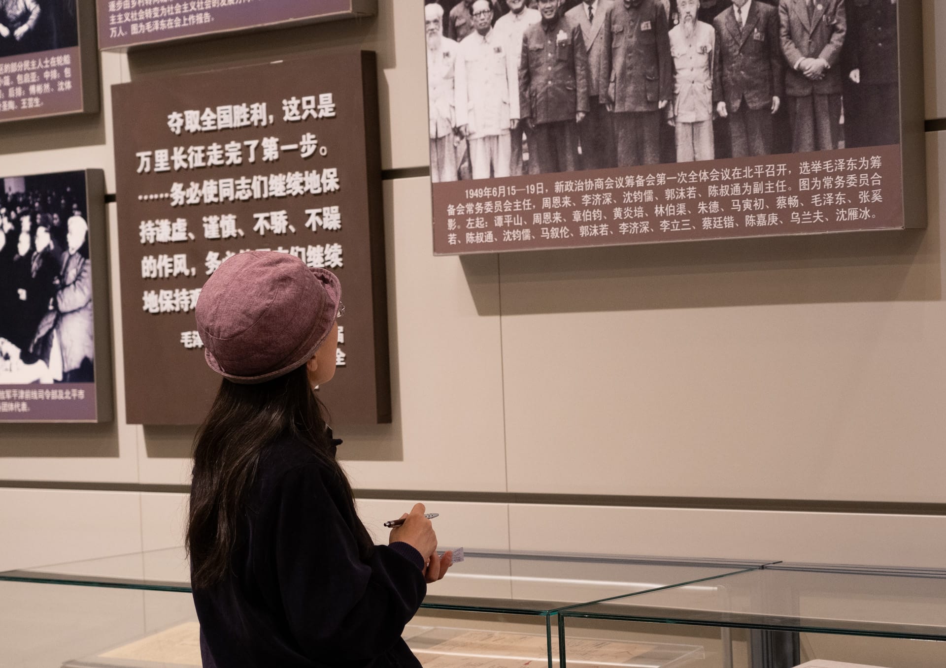 瞻仰先辈英雄往事,驻足观看并做记录的年轻人